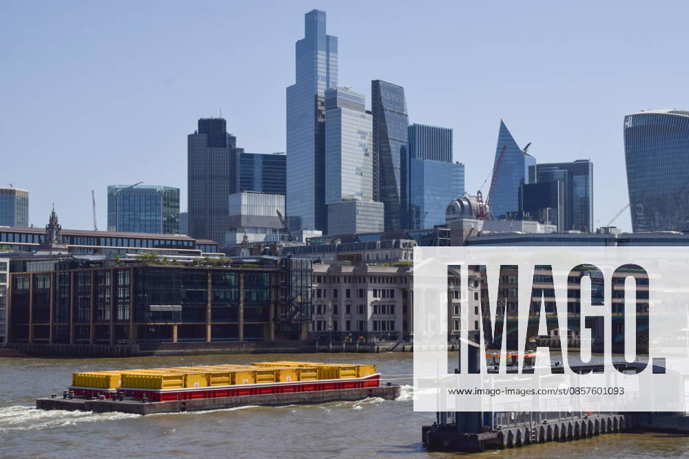 A boat pulling containers passes by the City of London skyline, the capital s financial district. London United Kingdom - ZUMAv130 20260526_zip_v130_007