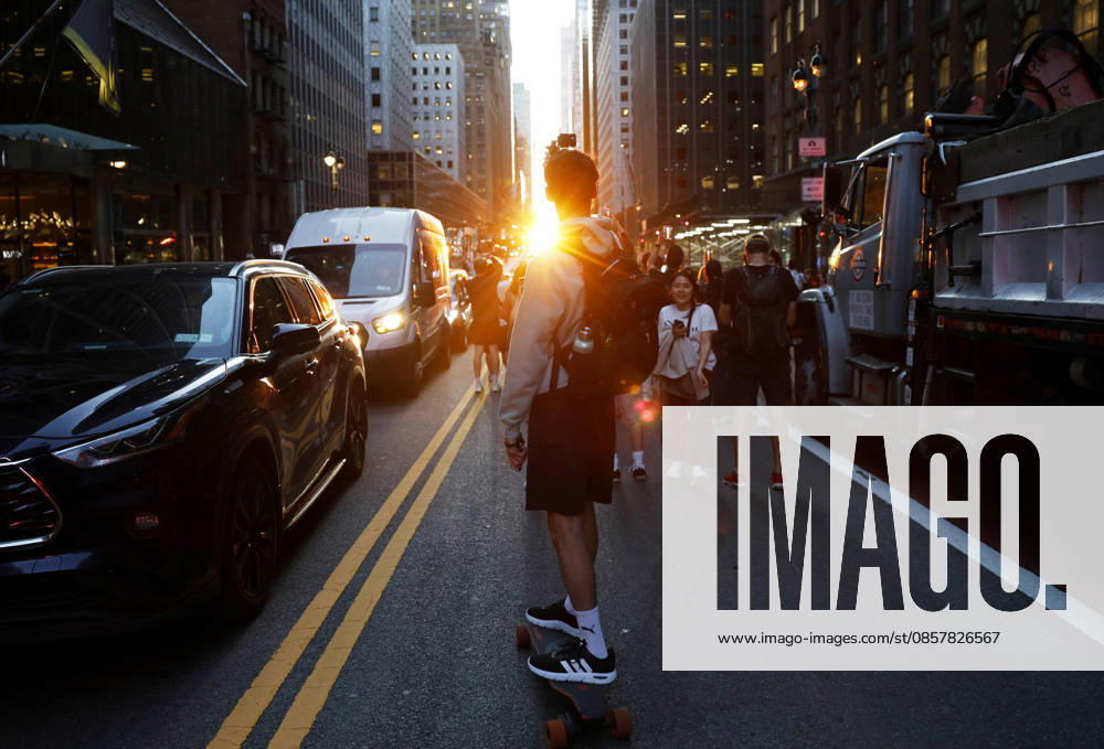 A skateboarder captures content with a cell phone while riding on 42nd street for a Manhattanhenge sunset event in New York City on Thursday, May 28, 2026. The Manhattanhenge sunset comes twice a year when the setting sun aligns precisely with Manhattan s street grid. NYP20260528202 JohnxAngelillo