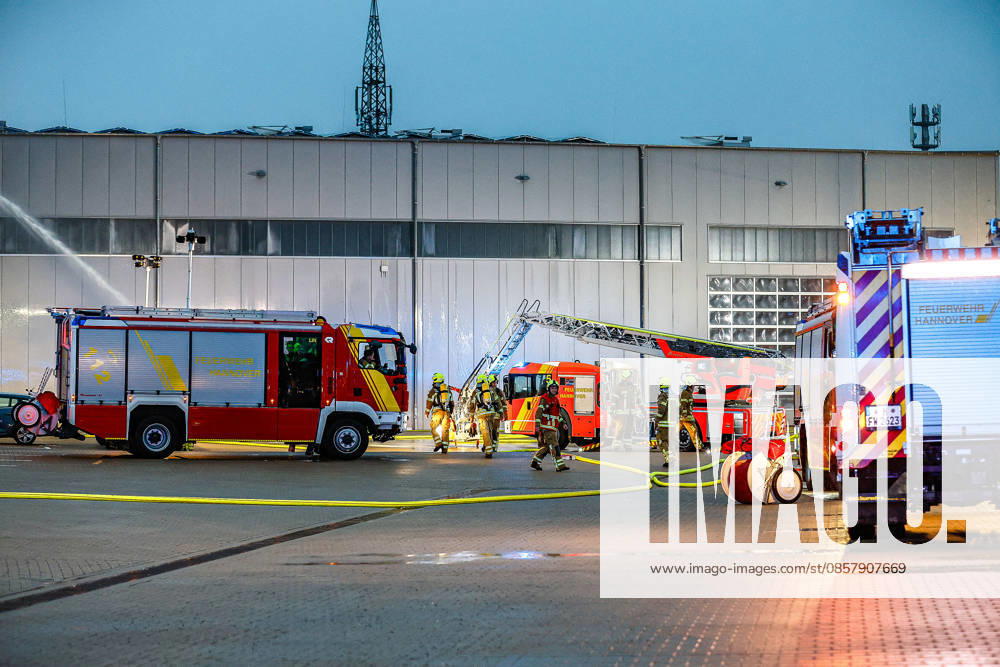 Large fire in a warehouse and logistics hall Use of a water cannon on the ground at the rear left to discharge extinguishing water onto the roof A turntable ladder is brought into position Hanover Anderten Lohweg 7, Lower Saxony industrial estate, Hanover region Germany
