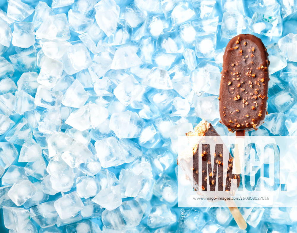 Crème-Brûlée-Eis am Stiel. Cream brulee ice cream popsicles covered milk chocolate and nuts on ice. Top view. (License=RF)