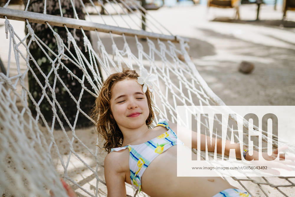 Smiling girl relaxing in hammock during tropical family vacation. Smiling girl relaxing in hammock during tropical family vacation. Summer holiday. model released