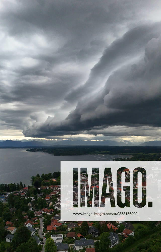 An early summer day in Tutzing, Starnberg district Here the view over the village and Lake Starnberg with the Alps on the horizon, where a thunderstorm is just coming up, a wall of clouds, thunderstorm roll, cloud roll, thunderstorm front, thunderstorm roll, thunderstorm front, dark clouds, weather picture