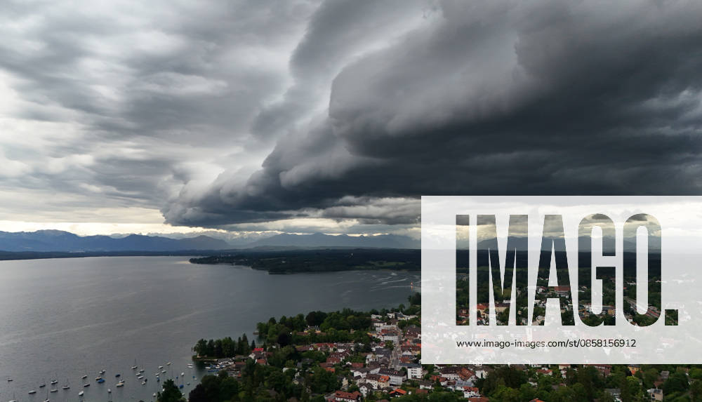 An early summer day in Tutzing, Starnberg district Here the view over the village and Lake Starnberg with the Alps on the horizon, where a thunderstorm is just coming up, a wall of clouds, thunderstorm roll, cloud roll, thunderstorm front, thunderstorm roll, thunderstorm front, dark clouds, weather picture