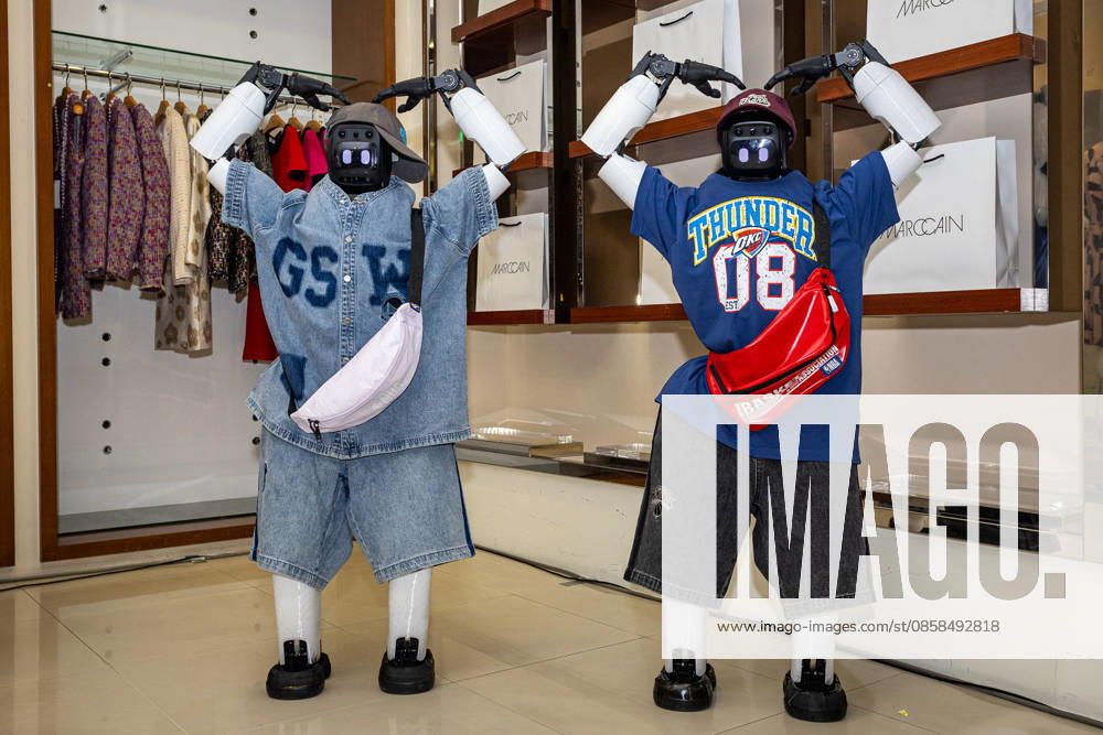 Two bipedal humanoid robots wearing trendy streetwear outfits, caps, and waist bags pose inside a clothing boutique during the EDA Fashion Show event at E-DA Outlet Mall in Kaohsiung on June 6, 2026. Kaohsiung City Taiwan - ZUMAh198 20260606_zip_h198_010