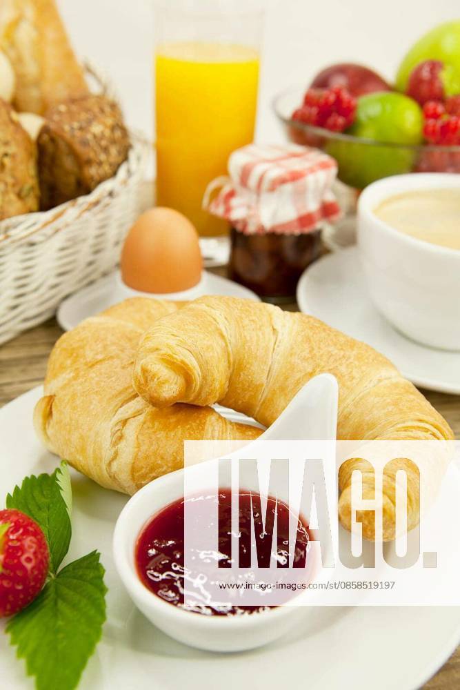 French breakfast with croissant,juice and jam on a wooden table