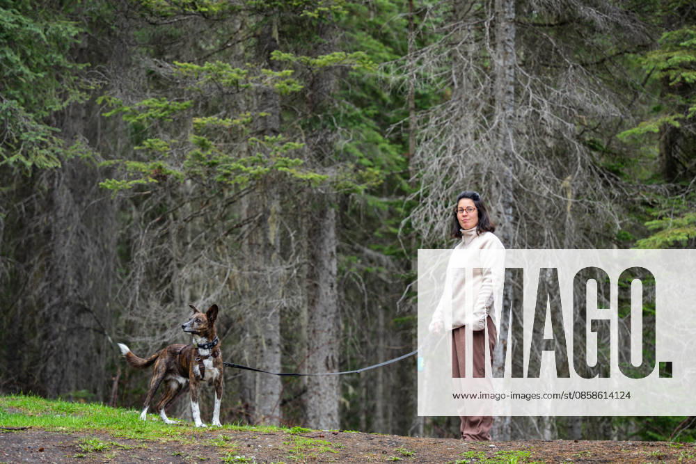 Woman and dog enjoying a walk on a trail through a green forest Field, British Columbia, Canada CR_UGOUSD260604-2044026-01 ,model released, Symbolfoto