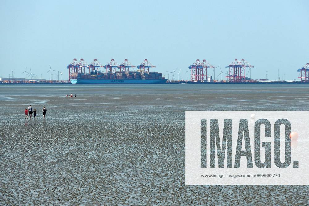 View from Friesenstrand beach in the North Sea resort of Tossens, a district of the municipality of Butjadingen in the district of Wesermarsch in Lower Saxony, of the North Sea bay of Jade Bay with dry mudflats In the background is the deep-water port Jade Weser Port JWP Wilhelmshaven The Wadden Sea is a UNESCO World Heritage Site