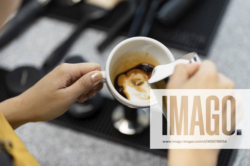 IMAGO Creative, Food, Trend, Iced Coffee Ein Barista bereitet gekonnt Kaffee in einem lebendigen Startup Café zu und präsentiert die Essenz der kleinen Unternehmen und der modernen Kaffeekultur A barista skillfully prepares coffee in a vibrant startup cafe, showcasing the essence of small business and modern coffee culture
