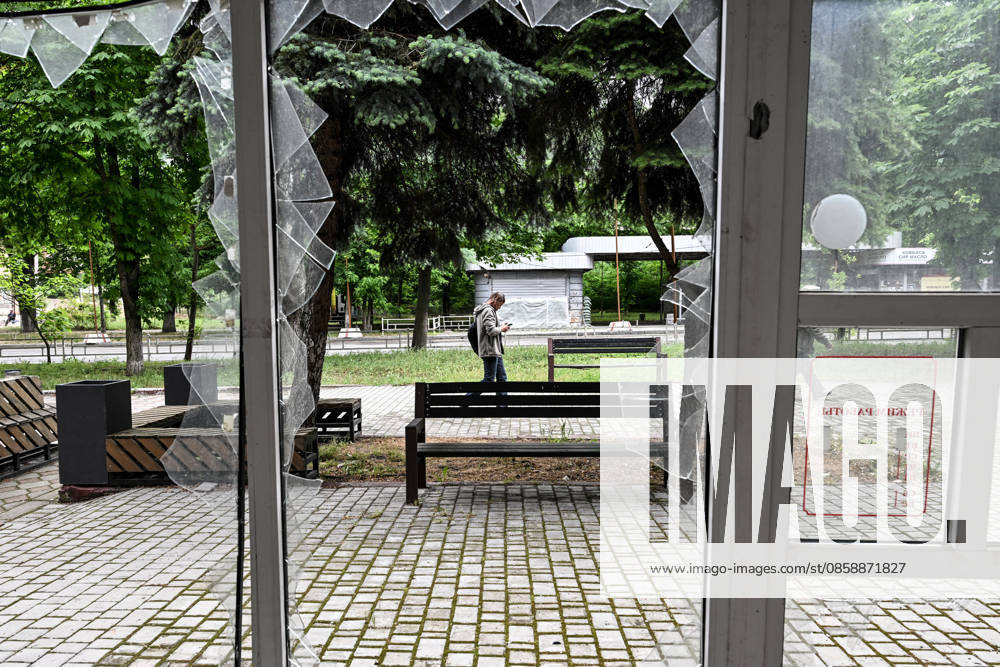 Lone pedestrians are seen through a shattered storefront window in the red zone of the frontline city of Kherson, the area considered the most dangerous due to constant Russian attacks, Kherson, Ukraine, on June 3, 2026. The Russian army attacks the city daily with FPV drones and other unmanned aerial vehicles, deliberately terrorizing civilians. Russian forces conduct hunts for local residents, tracking them with FPV drones and dropping explosives. Police officers, medics, public transport, and urban infrastructure are also targeted. Based on the intensity of attacks, Kherson is informally divided into yellow and red zones, with the red zone subjected to continuous shelling and drone strikes. Anti-drone netting has been installed