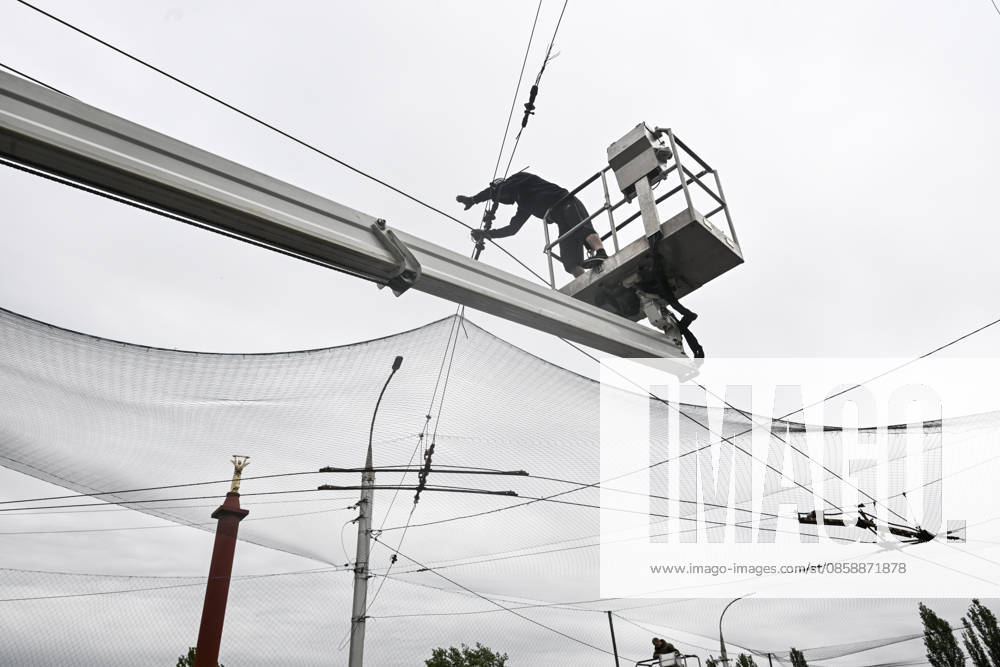 A municipal worker installs anti-drone netting to protect against Russian FPV drones in the yellow zone of the frontline city of Kherson, Ukraine, on June 3, 2026. The Russian army attacks the city daily with FPV drones and other unmanned aerial vehicles, deliberately terrorizing civilians. Russian forces conduct hunts for local residents, tracking them with FPV drones and dropping explosives. Police officers, medics, public transport, and urban infrastructure are also targeted. Based on the intensity of attacks, Kherson is informally divided into yellow and red zones, with the red zone being the most dangerous due to constant shelling and drone strikes (Photo by Dmytro Smolienko Ukrinform) Life under shelling in frontline Kherson