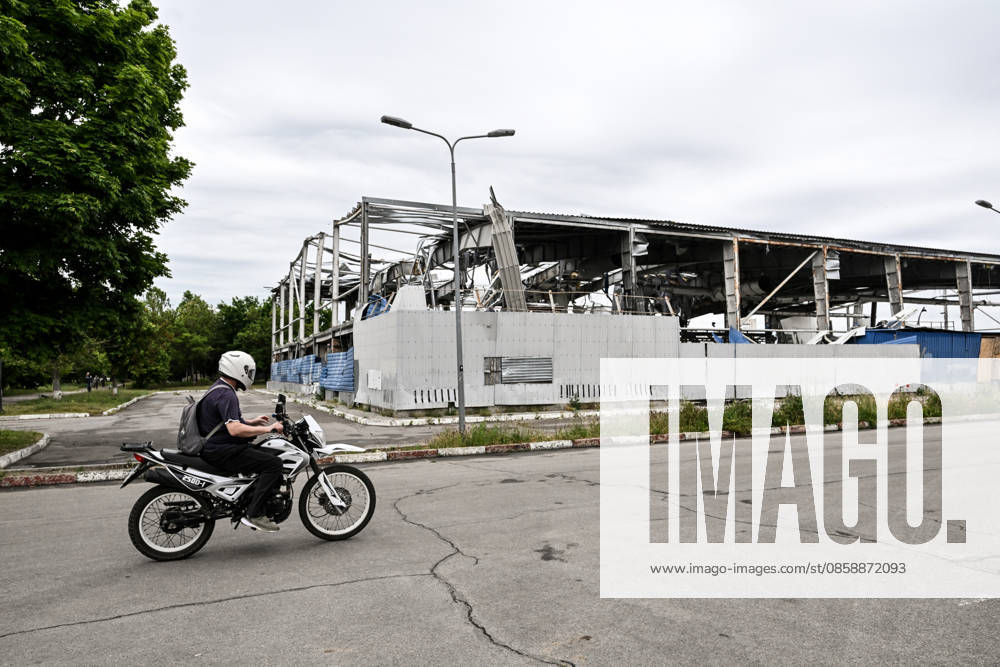 A motorcyclist rides past the Favoryt Arena ice sports palace, destroyed in Russian guided aerial bomb (KAB) strikes, in the frontline city of Kherson, Ukraine, on June 3, 2026. The Russian army attacks the city daily with FPV drones and other unmanned aerial vehicles, deliberately terrorizing civilians. Russian forces conduct hunts for local residents, tracking them with FPV drones and dropping explosives. Police officers, medics, public transport, and urban infrastructure are also targeted (Photo by Dmytro Smolienko Ukrinform) Life under shelling in frontline Kherson
