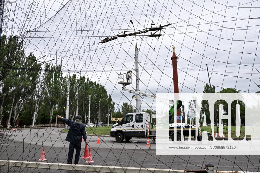 Municipal workers install anti-drone netting to protect against Russian FPV drones in the yellow zone of the frontline city of Kherson, Ukraine, on June 3, 2026. The Russian army attacks the city daily with FPV drones and other unmanned aerial vehicles, deliberately terrorizing civilians. Russian forces conduct hunts for local residents, tracking them with FPV drones and dropping explosives. Police officers, medics, public transport, and urban infrastructure are also targeted. Based on the intensity of attacks, Kherson is informally divided into yellow and red zones, with the red zone considered the most dangerous due to constant shelling and drone strikes (Photo by Dmytro Smolienko Ukrinform) Life under shelling in frontline Kher