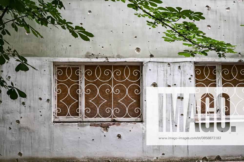 A building damaged by shrapnel from Russian attacks is seen in the frontline city of Kherson, Ukraine, on June 2, 2026. The Russian army attacks the city daily with FPV drones and other unmanned aerial vehicles, deliberately terrorizing civilians. Russian forces conduct hunts for local residents, tracking them with FPV drones and dropping explosives. Police officers, medics, public transport, and urban infrastructure are also targeted. Based on the intensity of attacks, Kherson is informally divided into yellow and red zones, with the red zone considered the most dangerous due to constant shelling and drone strikes. Anti-drone netting has been installed above roads to help protect against Russian FPV drone attacks (Photo by Dmytro S