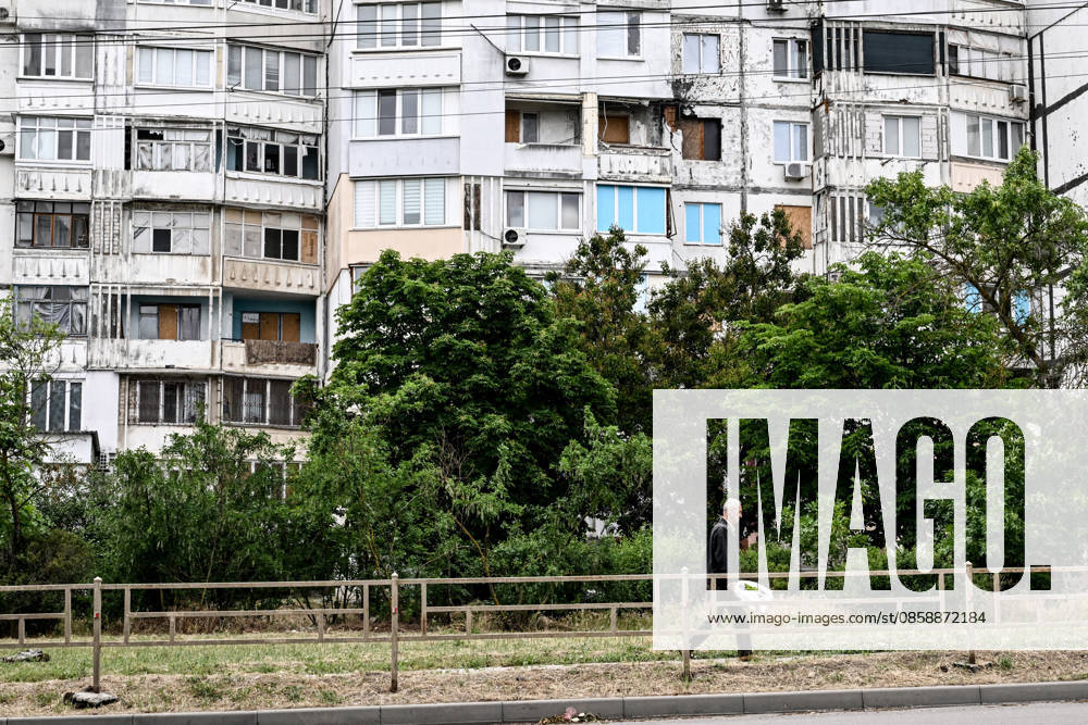 A man walks past a residential building damaged by Russian shelling in the frontline city of Kherson, Ukraine, on June 2, 2026. The Russian army attacks the city daily with FPV drones and other unmanned aerial vehicles, deliberately terrorizing civilians. Russian forces conduct hunts for local residents, tracking them with FPV drones and dropping explosives. Police officers, medics, public transport, and urban infrastructure are also targeted. Based on the intensity of attacks, Kherson is informally divided into yellow and red zones, with the red zone considered the most dangerous due to constant shelling and drone strikes. Anti-drone netting has been installed above roads to help protect against Russian FPV drone attacks (Photo by