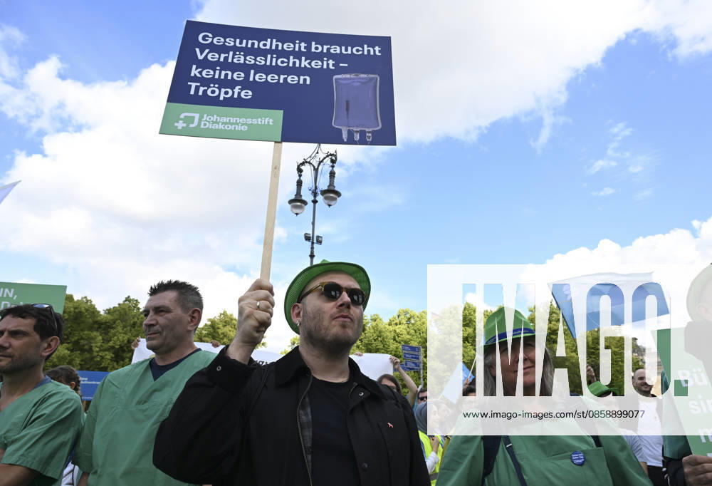 Demonstrators protest healthcare cuts in Berlin by smashing hospital beds BERLIN, GERMANY - JUNE 11: Members of the Berlin Hospital Association and the ver.di trade union take part in the Save the Clinics Now protest in front of the Brandenburg Gate in Berlin, Germany, on June 11, 2026, where an excavator symbolically smashes two hospital beds to protest planned cuts to hospital services. Halil Sagirkaya Anadolu Berlin Germany. Editorial use only. Please get in touch for any other usage.