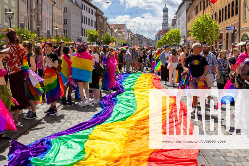 Augsburg, Bavaria, Germany June 13, 2026: Participants carrying rainbow flags and wearing colorful costumes take part in Christopher Street Day (CSD) in Augsburg. The parade through the city center promotes the rights of LGBTQ+ people as well as social diversity and tolerance. Participants unfurl a large rainbow flag