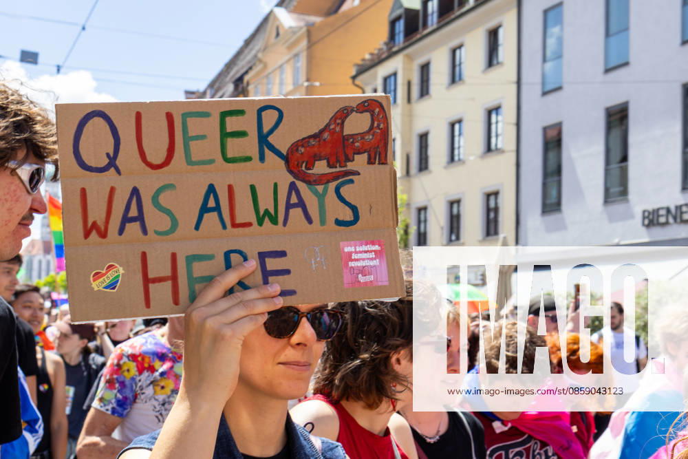 Augsburg, Bavaria, Germany June 13, 2026: Participants carrying rainbow flags and wearing colorful costumes take part in Christopher Street Day (CSD) in Augsburg. The parade through the city center promotes the rights of LGBTQ+ people as well as social diversity and tolerance. A participant holds a sign reading: QUEER WAS ALWAYS HERE