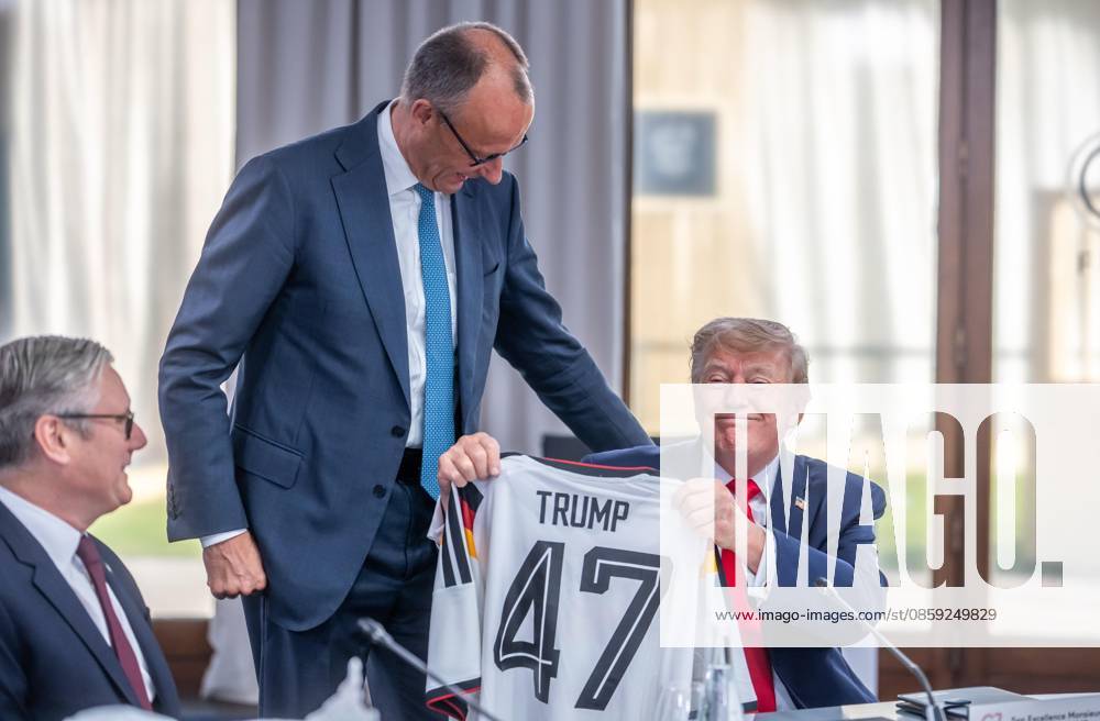 Hotel Royal G7 Summit Friedrich Merz presents a German soccer jersey to U.S. President Donald Trump Keir Starmer looks on Photo by Michael Kappeler, Pool,detected_source_language