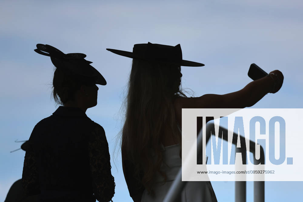Ascot, Windsor, GBR Fashion, women wearing hats at the racetrack silhouetted against the sky Ascot racetrack spectators, visitors, audience, women, hats, headwear, fashion, elegance, elegant, fashion, fashionable, feminine, rear view, silhouette, outline, backlit, backlit shot 260616D503ROYAL ASCOT JPG,detected_source_language