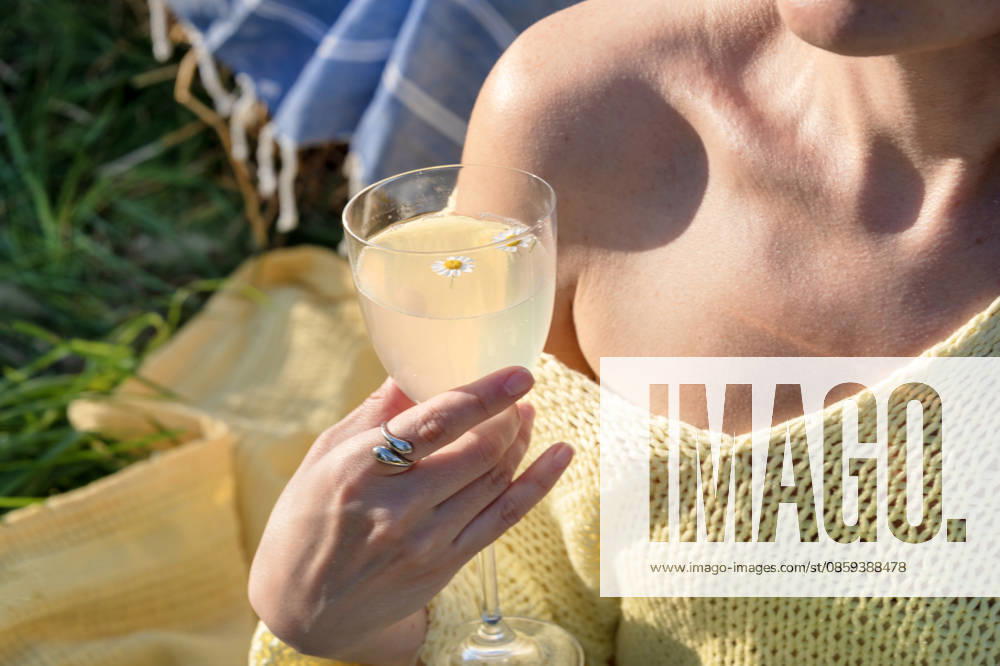 Woman holding a glass of floral lemonade or limoncello while relaxing R_YEPI260616-2055186-01 ,model released, Symbolfoto