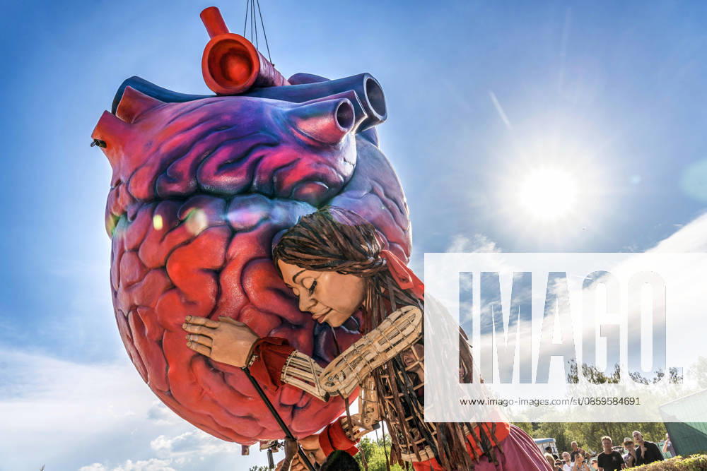 Eröffnung des Tollwood Sommerfestivals 2026, Little Amal begleitet die Festival-Eröffnung, die berühmte 3,5 Meter große Puppe, die das zehnjährige syrische Flüchtlingsmädchen Amal verkörpert, Amal umarmt die überlebensgroße Skulptur eines Deutschland, München, 19. Juni 2026, Eröffnung des Tollwood Sommerfestivals 2026, Little Amal begleitet die Festival-Eröffnung, die berühmte 3,5 Meter große Puppe, die das zehnjährige syrische Flüchtlingsmädchen Amal verkörpert, wurde weltweit zu einem Sinnbild für Hoffnung und Menschlichkeit, Little Amal umarmt die überlebensgroße Skulptur eines anatomischen Herzens, das Symbol des Festivals, das Tollwood ist ein multikulturelles Festival, das im Sommer im Olympiapark sta