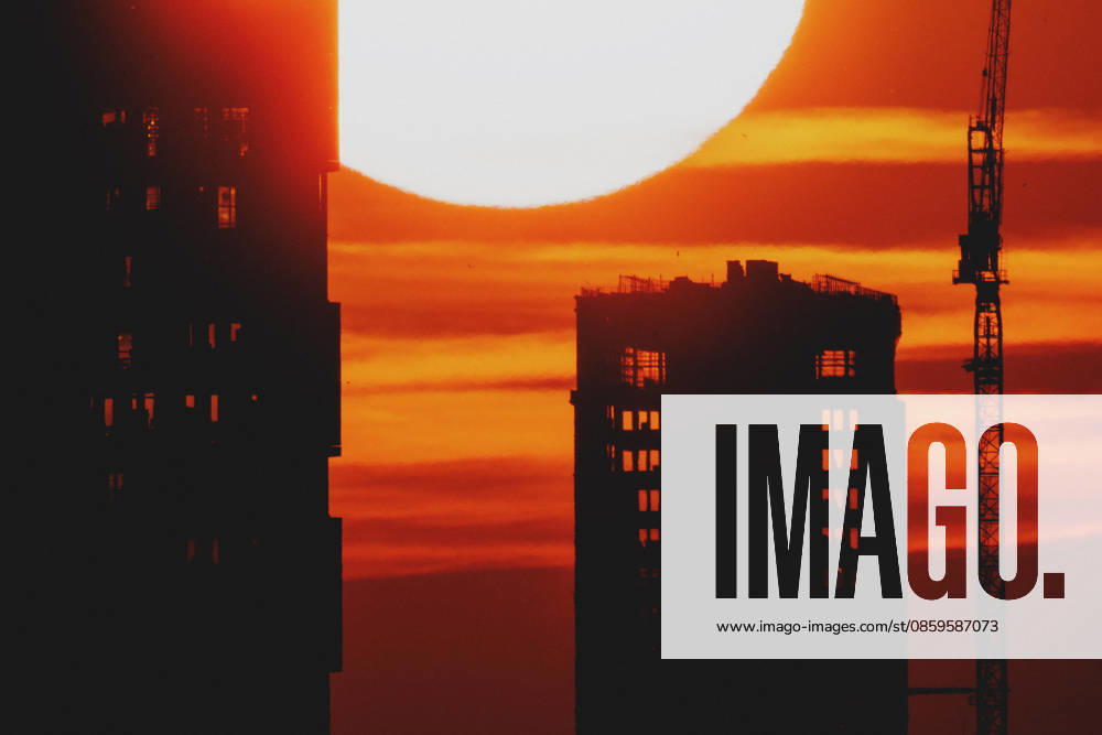 The setting sun is visible behind a new building with a crane in Berlin, June 19, 2026. A heat wave is currently affecting all of Germany. Berlin, Germany,detected_source_language