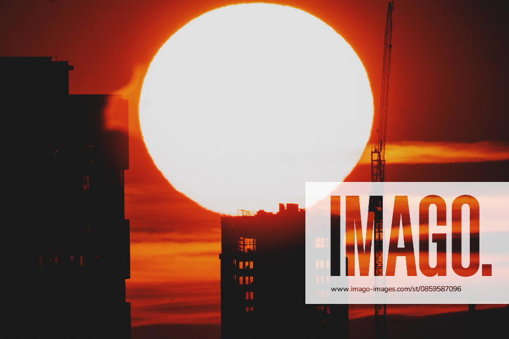 The setting sun is visible behind a new building with a crane in Berlin, June 19, 2026. A heat wave is currently affecting all of Germany. Berlin, Germany,detected_source_language