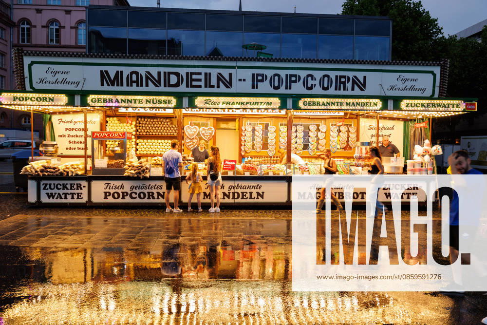 St. Johns Night, Mainz, June 19, 2026 A summer thunderstorm provides a brief respite; in the background, a stand selling roasted almonds and popcorn. Scenes from St. Johns Night in downtown Mainz, Current Events, Rhineland-Palatinate, St. John’s Night in Mainz on June 19, 2026; downtown Mainz; Rhineland-Palatinate; Germany,detected_source_language