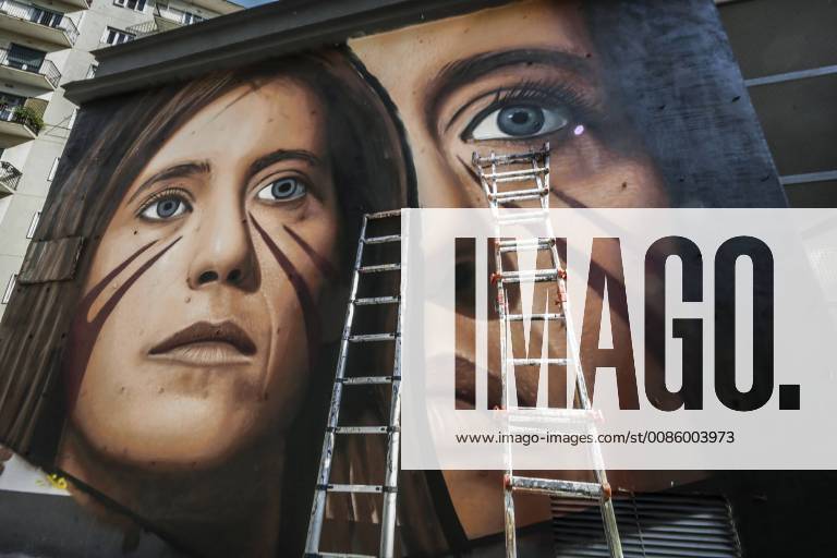 Naples, the street artist Jorit while working on the mural depicting Ilaria Cucchi, in the Arenella district. Dozens of passersby photograph him and bring him support, food and drink. 12 10 2018, Naples, Italy