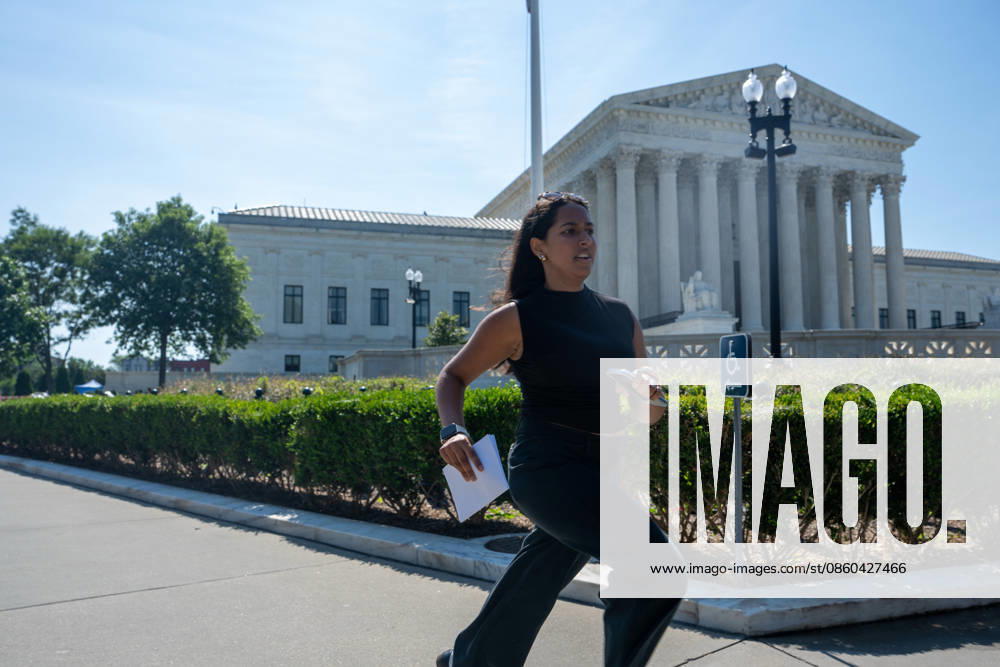 Interns working for media outlets run paper copies of Superme Court decisions to the on-air analysts outside of the Supreme Court on June 30, 2026. Despite digital options, the â€oerunning of the internsâ€� occurs annually at the Supreme Court at the end of the term. Washington United States - ZUMAl312 20260630_znp_l312_005