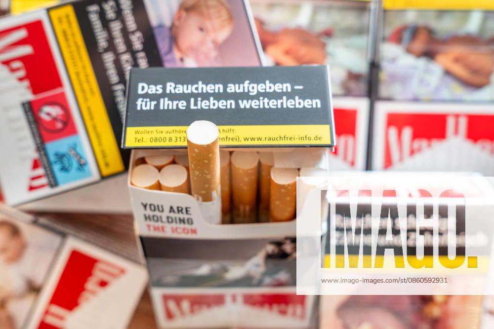 Several packs of cigarettes and an open cigarette pack with warning labels (such as: Quit smoking live on for your loved ones) encouraging people to quit smoking. The image symbolizes the health risks of smoking, nicotine addiction, prevention, the motivation to quit smoking, and the burden that smoking-related illnesses place on the German healthcare system.