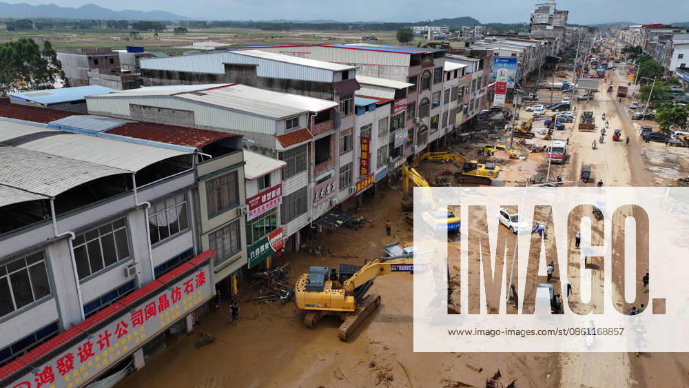 (260709) -- NANNING, July 9, 2026 -- A drone photo shows people removing silt and debris from a street after floodwater recedes in Yunbiao Town of Hengzhou City, south China s Guangxi Zhuang Autonomous Region, July 9, 2026. Recent extreme rainstorms triggered by Typhoon Maysak, the 10th typhoon of the year, have caused severe flooding in parts of Guangxi in the Pearl River basin. Guangxi is continuing its search and rescue operations for missing persons, enhancing resettlement services for affected residents and advancing post-disaster reconstruction. ) FOCUS Guangxi makes all-out rescue, relief efforts after rain-triggered disasters HuangxXiaobang