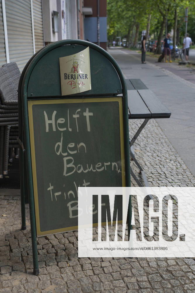 A sign reading Help the Farmers, Drink Beer in front of a restaurant on Rummelsburger Straße in Berlin-Lichtenberg