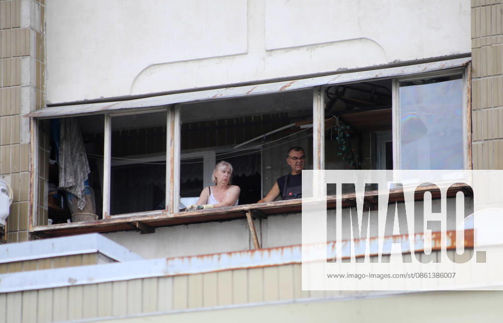 A man and a woman stand at the window of a residential building damaged by a Russian ballistic missile strike in the Darnytskyi district of Kyiv, Ukraine, on July 11, 2026. During the night of July 11, Russian forces launched their third ballistic missile attack on Kyiv in a week. Twelve people, including two children aged 10 and 11, were injured (Photo by Yuliia Ovsiannikova Ukrinform) Cleanup underway after Russian attack in Darnytskyi district of Kyiv