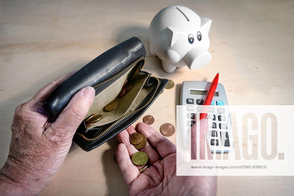 Alte Hände, die Münzen aus einer fast leeren Brieftasche zählen, ein Sparschwein und ein Taschenrechner mit einem roten Stift vor einem hellen Holzhintergrund; Konzept für eine unzureichende Altersrente Old hands counting coins from an almost empty wallet, piggy bank and calculator with a red pen on a light wooden background, concept for an insufficient retirement pension (License=RF)