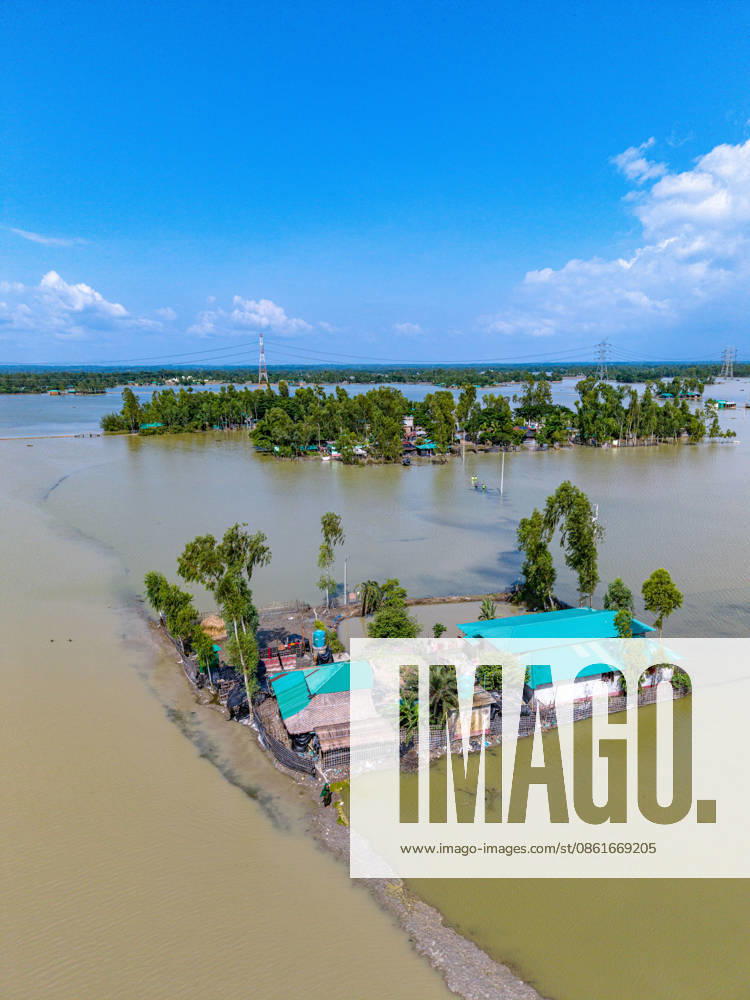 Aftermath Of Floodwaters In Chattogram A drone shot captures homesteads with distinctive green tin roofs isolated like small islands amid vast stretches of floodwater in Banshkhali, Chattogram, Bangladesh, on July 14, 2026. Although flood waters in Banshkhali and Satkania in Chittagong are slowly receding, many areas remain knee-deep in water. As the water recedes, collapsed mud houses, damaged structures, destroyed brick kilns and severely damaged agricultural land are becoming visible, displacing thousands of people. Chattogram Bangladesh