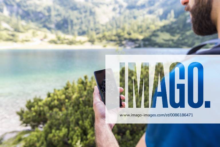 Austria, Tyrol, Hiker using compass app at Lake Seebensee model released Symbolfoto DIGF04755