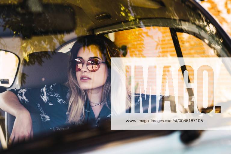 Young woman wearing sunglasses sitting in a car model released Symbolfoto KKAF01353