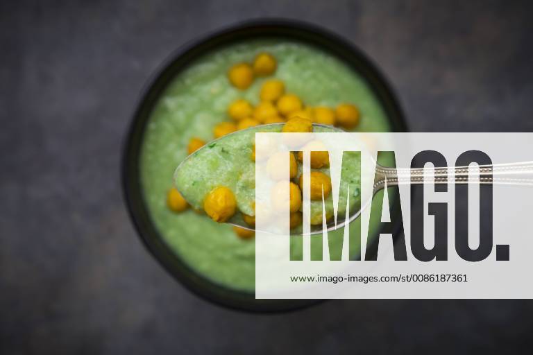 IMAGO Nature: Unsere Erde, Klimawandel, Ernährung, Pflanzen der Zukunft, Kichererbse Bowl of green gazpacho with avocado and curcuma roasted chick peas, on spoon, close-up LVF07433