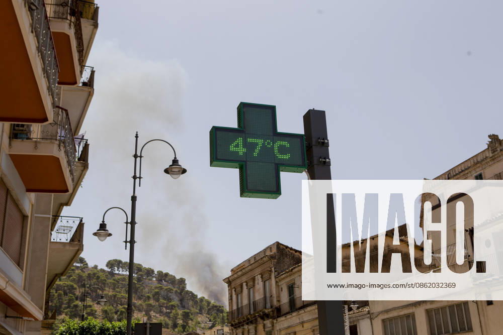 KW29 Modica Italy Heatwave A pharmacy sign displays a temperature of 47 degrees Celsius as smoke from a wildfire rises in the background during a heatwave in Modica, Sicily, Italy, on July 18, 2026. Wildfires were reported in parts of Sicily as high temperatures persisted across southern Italy. Modica Ragusa Italy