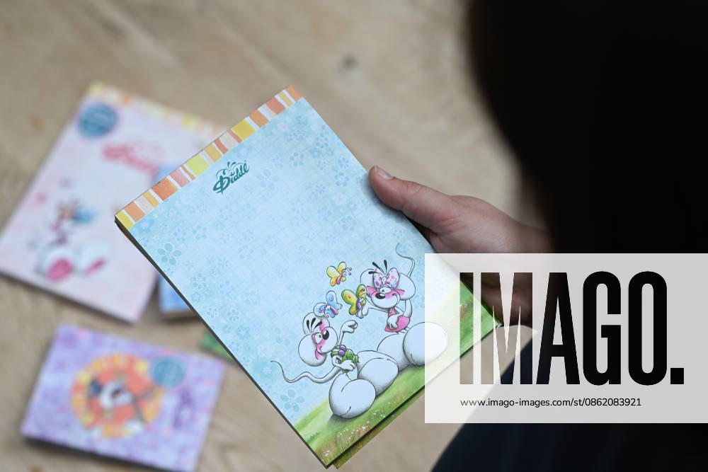 Diddl Makes a Comeback in Germany A woman holds a current Diddl notebook in her hand. After more than a decade, the iconic plush mouse is returning to the German market, prompting many people to look back nostalgically on their school days. Berlin, Berlin, Germany