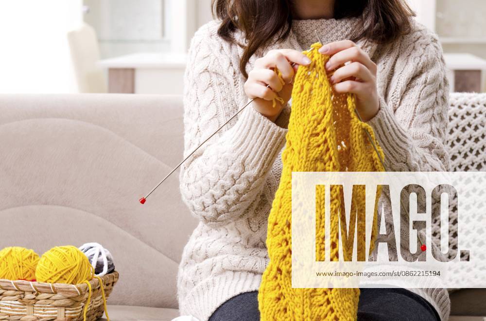 Junge schöne Frau strickt zu Hause Young beautiful woman knitting at home