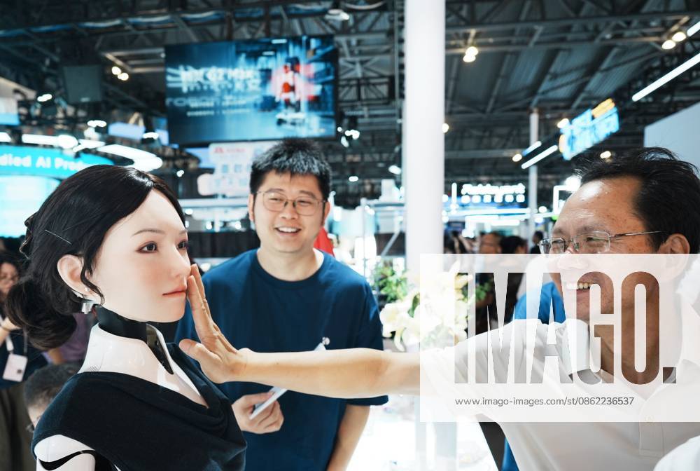 A visitor touches the bionic skin of a humanoid robot during the 2026 World AI Conference on July 20, 2026 in Shanghai, China. The conference showcases latest advancements in artificial intelligence and robotics technologies.
