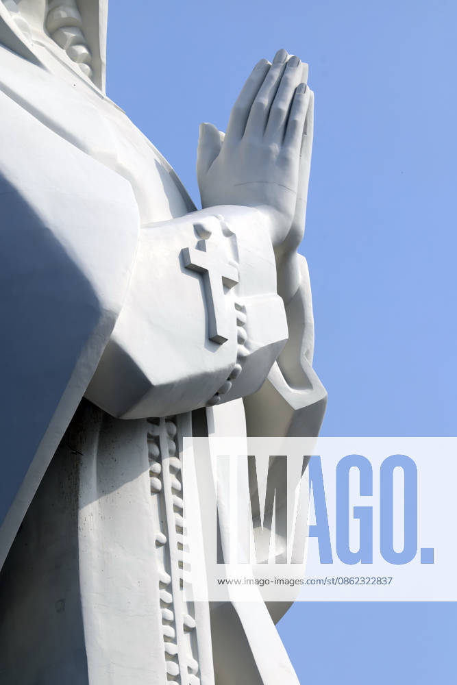 Nui Cui Marian Shrine. An imposing statue with hands clasped in prayer, adorned with a cross, symbolizes Christian faith and devotion. This religious monument invites contemplation and inner peace. Thong Nhat, Vietnam. Thong Nhat Dong Nai Vietnam
