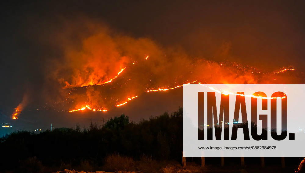 Wildfires continue in Italian island of Sicily PALERMO, ITALY - JULY 22: Wildfires that broke out in several parts of the Italian island of Sicily continue overnight, fueled by strong winds, as firefighters, civil protection teams and forestry crews press on with efforts to contain the blazes near Palermo, Sicily, Italy on July 22, 2026. The wildfires, which started yesterday on the slopes of Mount Longa near the city of Palermo, spread rapidly due to the wind and burned throughout the night. Alberto Lo Bianco Anadolu Palermo Italy. Editorial use only. Please get in touch for any other usage.