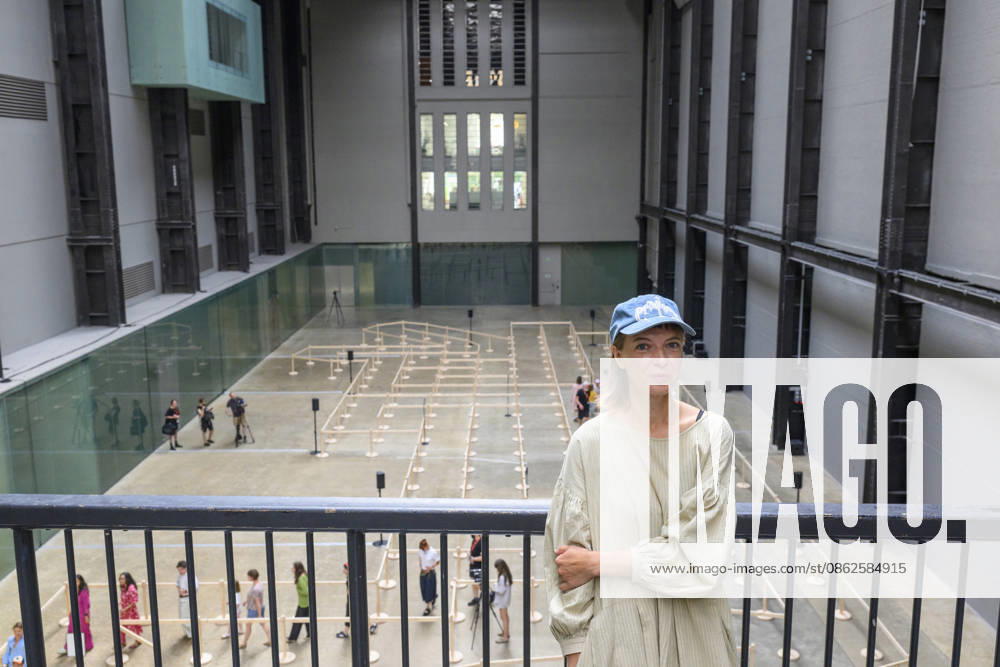 Artist Lina LapelytÄ poses with her created maze-like installation, transforming the Turbine Hall into a collaborative stage. Audiences are invited to co-create in a piece of mass choreography, moving through a grid of wooden barriers. You are also free to quietly watch the performance unfold, from the Turbine Hall bridge. London, UK. London UK - ZUMAl94_ 20260724_zaf_l94_003