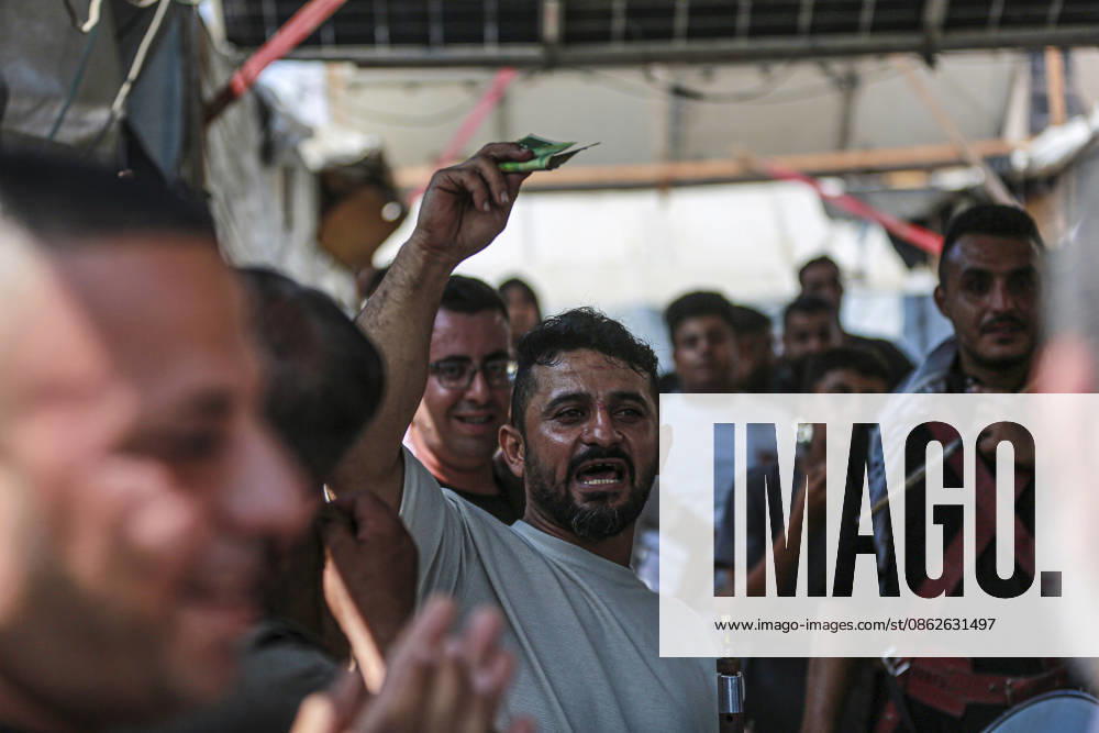 Gaza Families Celebrate Tawjihi Success A Palestinian man raises a banknote as residents gather during celebrations of the Tawjihi results in Gaza City, northern Gaza Strip, on July 23, 2026. Families in displacement camps and neighborhoods across northern Gaza City held modest celebrations for students who passed the Tawjihi examinations amid war, blockade and severe humanitarian conditions. Gaza Gaza Strip Palestinian Territories