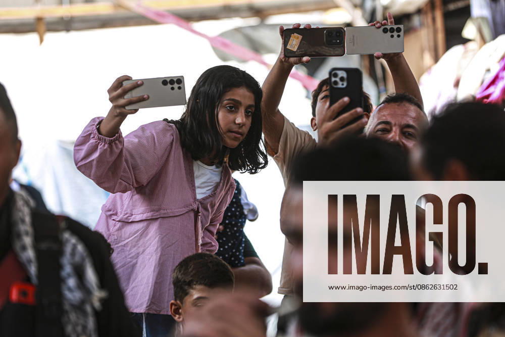 Gaza Families Celebrate Tawjihi Success A Palestinian girl records the gathering on a mobile phone as others hold up their phones during celebrations of the Tawjihi results in Gaza City, northern Gaza Strip, on July 23, 2026. Families in displacement camps and neighborhoods across northern Gaza City held modest celebrations for students who passed the Tawjihi examinations amid war, blockade and severe humanitarian conditions. Gaza Gaza Strip Palestinian Territories