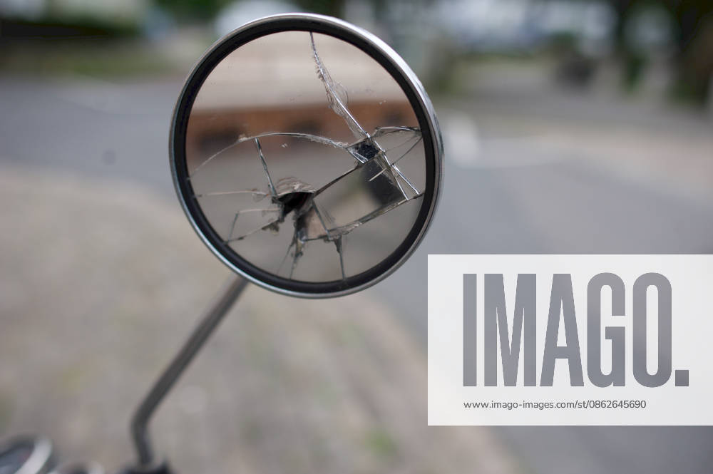 Flensburg, Schleswig-Holstein: Close-up of a round, chrome-plated rearview mirror from a scooter. The mirror glass is severely shattered, has deep cracks, and a hole in the center. Photo taken on July 25, 2026, in Flensburg