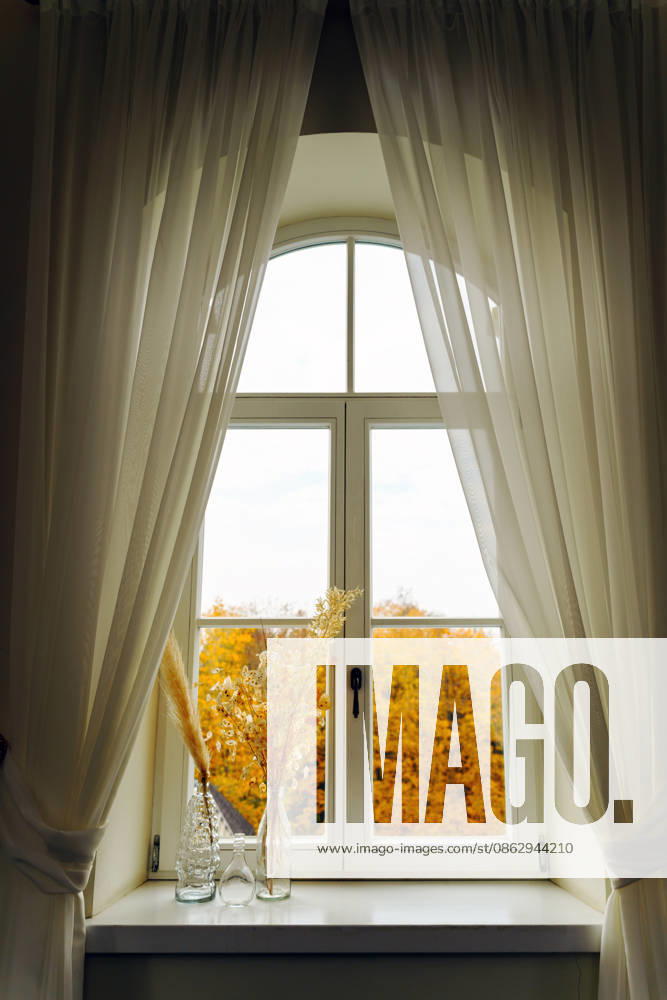 Sheer curtains frame an arched window autumn view Burbi?kis, Utena County, Lithuania CR_EDSAHG260728B-2089476-01 ,model released, Symbolfoto ,property released